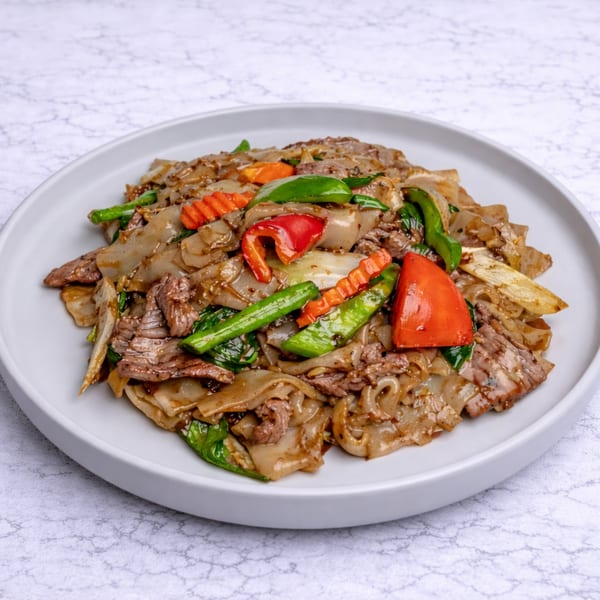Linjee Thai's Pad See Ew with wide noodles, beef, and colorful vegetables on a white plate.