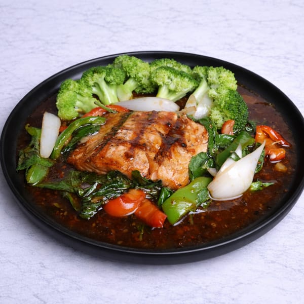 Linjee Thai's salmon dish with broccoli, onions, bell peppers, and basil in a dark sauce.